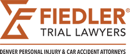 Logo for Fiedler Trial Lawyers, Denver personal injury and car accident attorneys. The logo features stylized orange text and graphics.